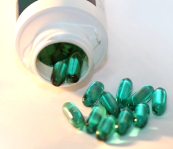 Medicine Bottle with green softgels
                    spilling out